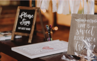 table-with-sign-that-asks-wedding-guests-to-sign-a-board