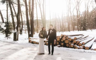 wedding couple standing outside in the snow holding hands