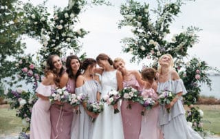 Beautiful elegant slim smiling bridesmaids in delicate pink beige summer dress on the wedding ceremony.