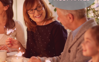 older woman sitting at table smiling with sparkler