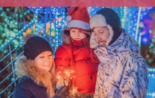 family-in-winter-clothes-lighting-sparklers-together-outside-in-the-snow