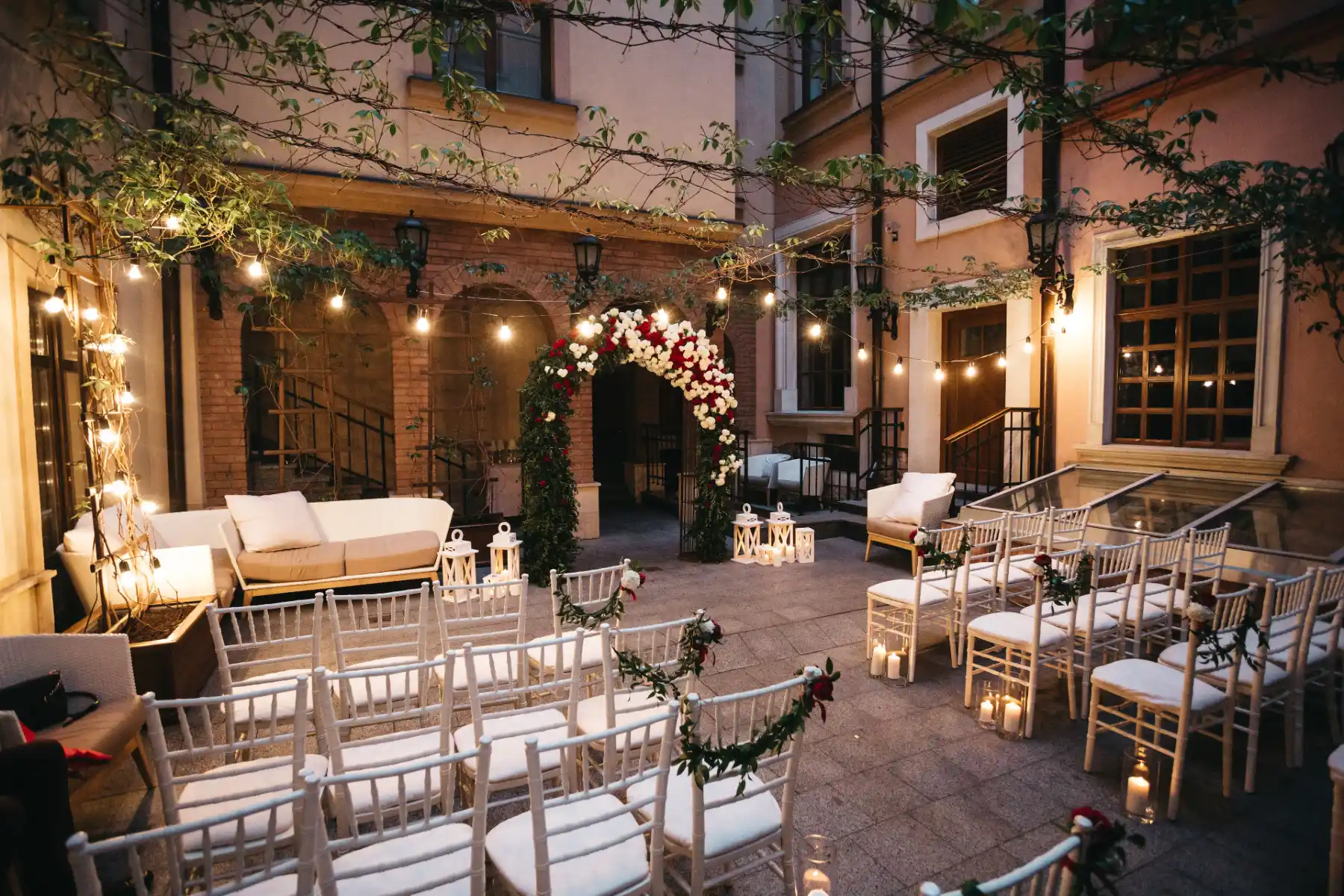 Red peonies and white hydrangeas pinned chairs before wedding
